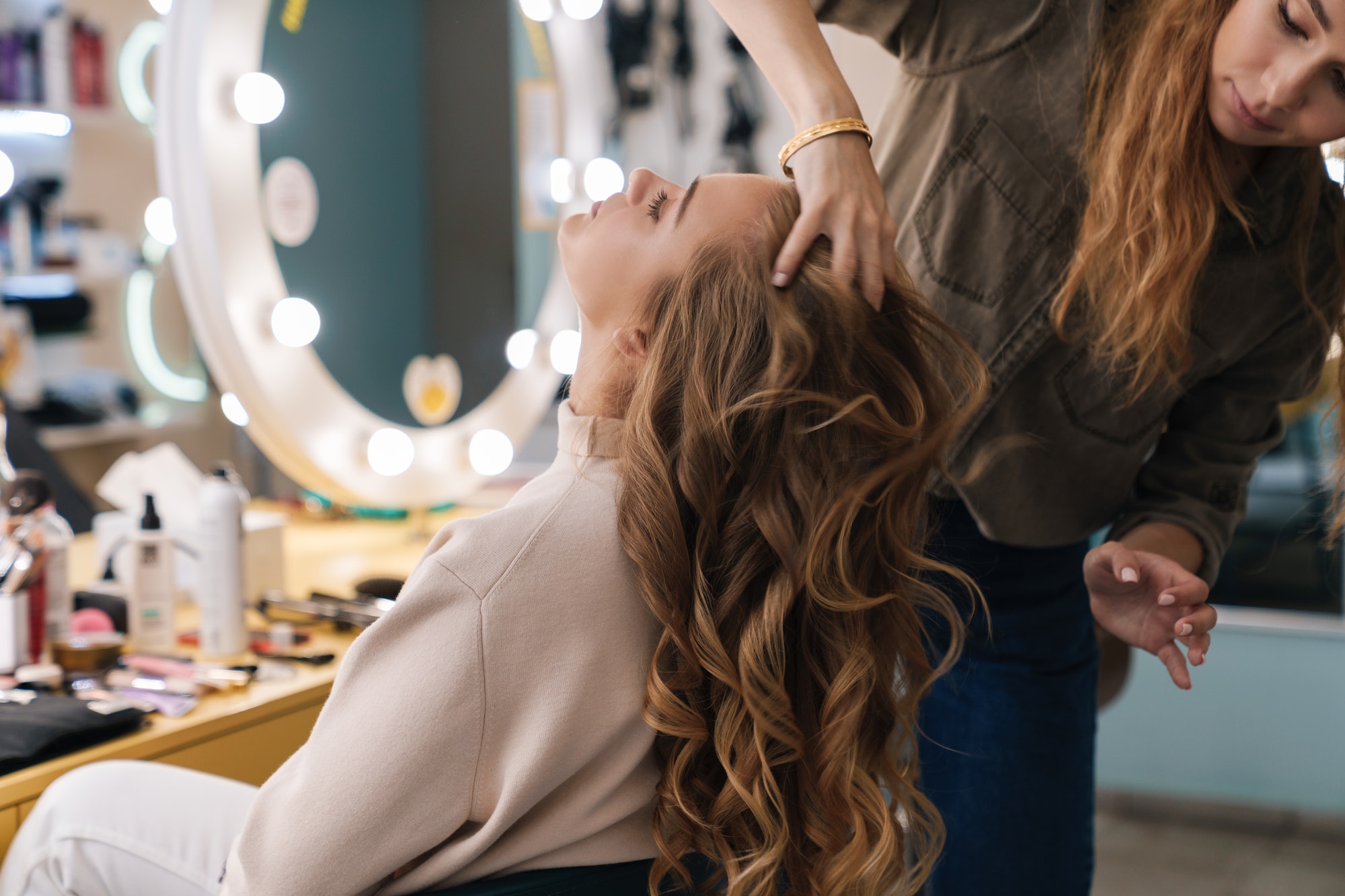 Peluquera peinando a una chica con rizos